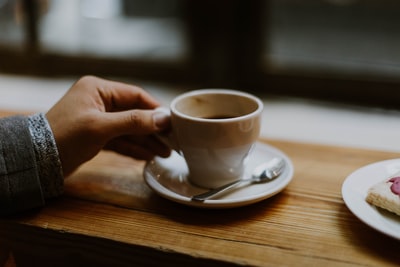 人拿着白色的陶瓷茶杯
